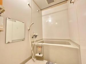 a white bathroom with a shower and a sink at AMSタワー中島 in Sapporo