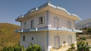 un edificio blanco con balcón en la parte superior en Vila Antigonea, en Gjirokastra