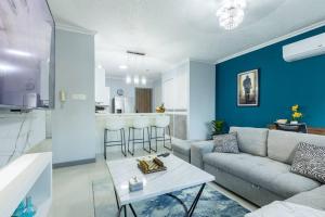 a living room with a couch and a table at Modern Luxury Apartment in New Kingston in Kingston