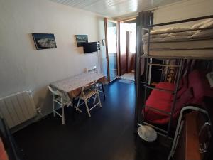 Habitación con cama, mesa y literas. en Studio 3 personnes au pied des piste plateau de Bonascre - Ax 3 domaines Eté Hiver en Ax-les-Thermes