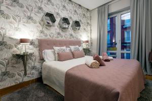 a bedroom with a pink bed with a pink blanket at Audrey by Unique Rooms in Burgos