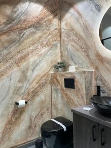 La salle de bains est pourvue d'un mur en pierre et d'un lavabo. dans l'établissement Hotel Rubin***, à Gheorgheni