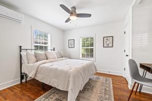 a white bedroom with a bed and a ceiling fan at Saints Street Charmer in Lafayette