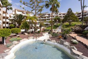 a swimming pool with a water slide in a resort at Oceanfront 2 bedrooms Holiday Home in Tenerife South in San Miguel de Abona