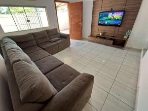 Il comprend un salon doté d'un canapé et d'une télévision à écran plat. dans l'établissement Casa Super Econômica com Café, à Foz do Iguaçu