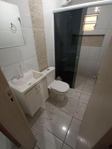 La salle de bains est pourvue de toilettes, d'un lavabo et d'une douche. dans l'établissement Casa Super Econômica com Café, à Foz do Iguaçu