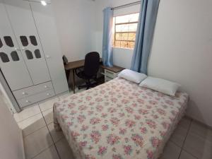 - une chambre avec un lit, un bureau et une fenêtre dans l'établissement Casa Super Econômica com Café, à Foz do Iguaçu