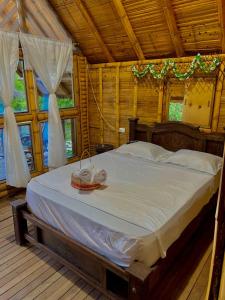 1 dormitorio con 1 cama grande con sábanas blancas en Hotel la Isla campestre, en Villavieja