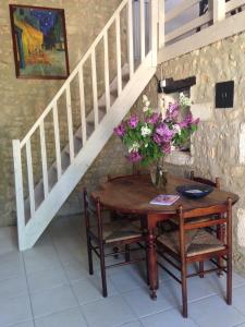 uma mesa com um vaso de flores ao lado de uma escada em Gites les Lignons em Champniers
