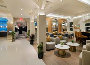 eine Lobby eines Hotels mit Sofas und Tischen in der Unterkunft voco Fiorello - LaGuardia East, an IHG Hotel in Flushing