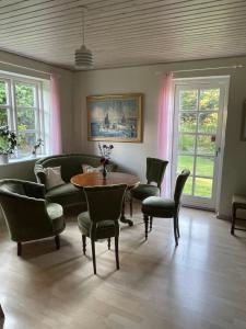 a living room with a table and chairs at Pedersholt Bed & Breakfast in Dybvad