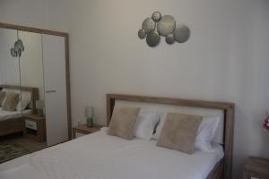 a bedroom with a bed with white sheets and a mirror at Real Resort-Apartament cu 2 camere in cartier rezidential in Ploieşti