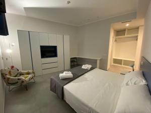 a bedroom with a bed and a chair and a television at LA DIMORA DEL FALEGNAME in Matera