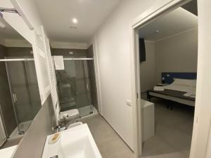 a bathroom with a sink and a mirror and a bed at LA DIMORA DEL FALEGNAME in Matera