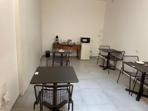 a room with tables and chairs and a kitchen at LA DIMORA DEL FALEGNAME in Matera