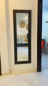 espejo en la pared con sofá en la habitación en Cabana dos Milagres aconchegante a 150m da praia e WI FI, en São Miguel dos Milagres