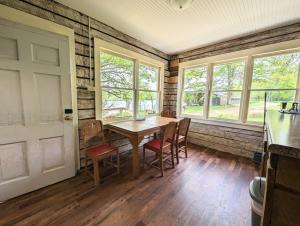 a dining room with a table and chairs and windows at Pilgrim Heights Camp & Retreat Center in Toledo