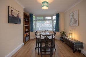 a dining room with a table and chairs and a window at Cosy home from home in Bournemouth