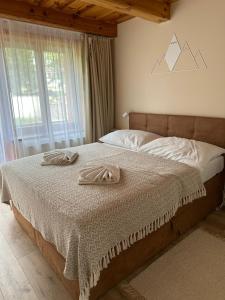 a bedroom with a bed with two towels on it at Apartmánik pri Zubačke in Tatranska Strba