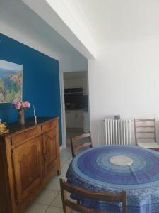 a dining room with a table and a blue wall at Appartement Saint Raphaël in Saint-Raphaël