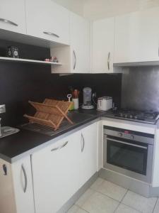 a kitchen with white cabinets and a stove top oven at Appartement Saint Raphaël in Saint-Raphaël