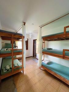 a room with three bunk beds in it at Hostel Coraticum in Ubatuba