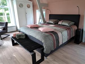 1 dormitorio con 1 cama grande con almohadas rosas en B&B Út en thús, 