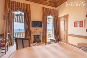 a bedroom with a fireplace and a view of the ocean at Estoril Vintage Hotel in Estoril