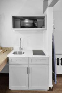 a white kitchen with a sink and a microwave at Econo Lodge in Carlsbad