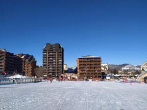 a view of a snowy beach with buildings in the background at Studio 3 personnes au pied des piste plateau de Bonascre - Ax 3 domaines Eté Hiver in Ax-les-Thermes