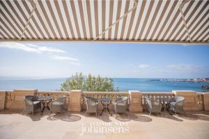- stół i krzesła na balkonie z widokiem na ocean w obiekcie Estoril Vintage Hotel w mieście Estoril