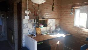 una pequeña cocina con encimera y fregadero en La Estacion en Santa Rosa de Calamuchita