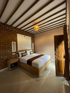 um quarto com uma cama e uma parede de tijolos em MyHome - Lombok em Tetebatu