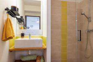 ein Bad mit einem Waschbecken und einer Dusche in der Unterkunft Ô Ti Pass Temps in Saint-Denis