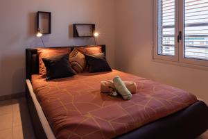 Un dormitorio con una cama grande con dos animales de peluche. en Ô Ti Pass Temps en Saint-Denis