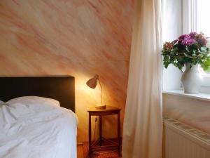 een slaapkamer met een bed en een raam met een plant bij Haus Der Malerin Andrea Gawaz in Müllheim