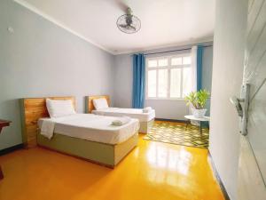 1 dormitorio con cama y ventana en Gallivanters Hostel, en Dar es Salaam