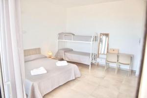 a bedroom with two beds and a table and chairs at Villa Quantum in Siculiana Marina