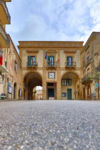 un gran edificio con un arco en medio de una calle en Rinaldo Holiday Home, en Sambuca di Sicilia