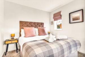 a bedroom with a large bed with a blanket at Wheatley House in Milton Keynes