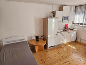 a small kitchen with a table and a bed in a room at VlbgApart Lauterach Bu76 in Lauterach