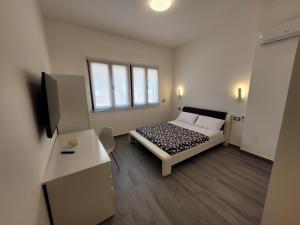 um pequeno quarto com uma cama e uma secretária em SP Rooms em Isola delle Femmine
