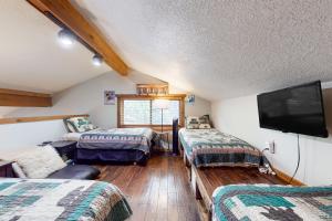 a room with two beds and a flat screen tv at The Lift #C2 in Angel Fire