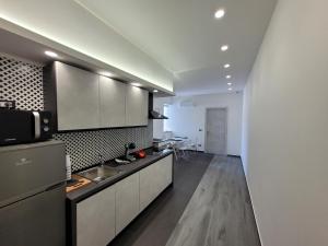 uma cozinha com armários brancos e uma bancada em SP Rooms em Isola delle Femmine