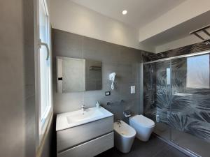 uma casa de banho com um lavatório, um chuveiro e um WC. em SP Rooms em Isola delle Femmine