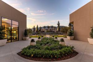 Le Méridien Pasadena Arcadia في أركاديا: مبنى به ساحة مع نباتات الفخار