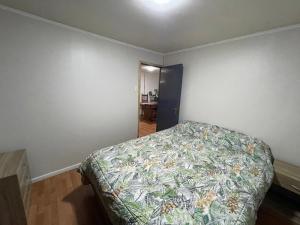 1 dormitorio con 1 cama con colcha colorida en Casa entera para 2 o 4 personas, en Temuco