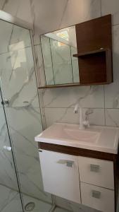 a bathroom with a sink and a shower at Flat Recanto da Natureza in Cabo de Santo Agostinho