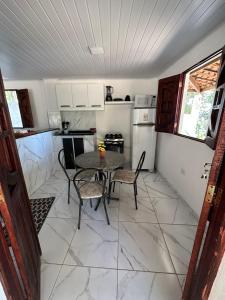 カボ・デ・サント・アゴスチーニョにあるFlat Recanto da Naturezaのキッチン(テーブル、椅子付)