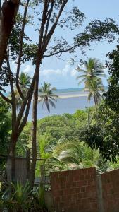 a view of the ocean from a brick wall with palm trees at Flat Recanto da Natureza in Cabo de Santo Agostinho